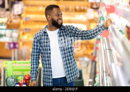 African Male Doing Shopping Stehen In Der Nähe Regal Im Lebensmittelgeschäft Stockfoto