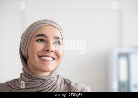Fröhliche arabische Frau in Hijab Blick auf den Kopierraum Stockfoto