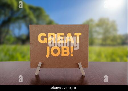 Tolle Arbeit Text auf Karte auf dem Tisch mit sonnigen grünen Park Hintergrund. Stockfoto