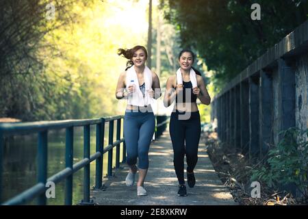 Läufer Fitness-Paar läuft im Stadtpark, zwei Frauen trainieren beim Joggen Stockfoto