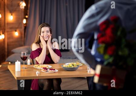 Liebevoller Mann Überraschende Freundin Mit Roten Rosen Bei Romantic Date Im Restaurant Stockfoto