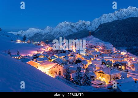 Traditionelles alpines Dorf Ardez bedeckt mit Schnee in der Dämmerung, Kanton Graubünden, Engadin, Schweiz Stockfoto