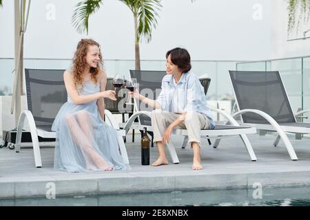 Junge Frauen klirren Weingläser Stockfoto