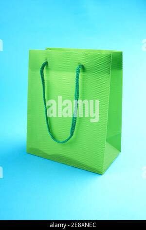 Leere grüne Einkaufstasche auf blauem Hintergrund. Einkaufs- und Verkaufskonzept Stockfoto