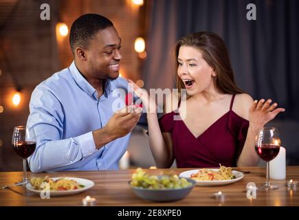 Vorschlag Überraschung. Romantische junge schwarze Mann schlägt Ehe zu seiner schönen Freundin Stockfoto