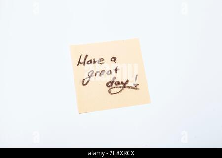 Lassen Sie eine großartige Tagesnachricht handschriftlich auf der gelben Post-it-Notiz Stockfoto