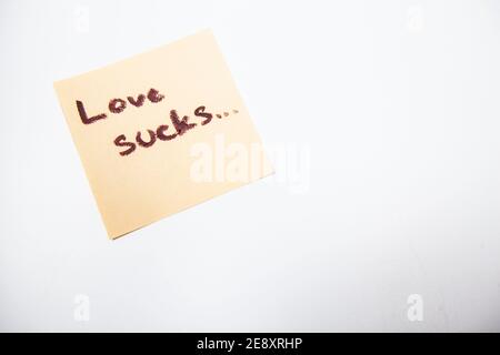 Liebe saugt auf gelbem Stück Papier geschrieben, isoliert Stockfoto
