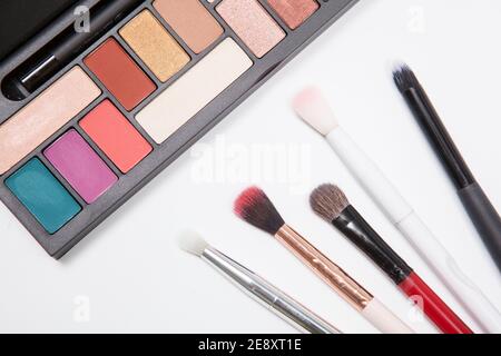 Beschnittene Ansicht von oben Nahaufnahme einer neuen Lidschatten-Pallete Und Make-up-Bürsten Stockfoto