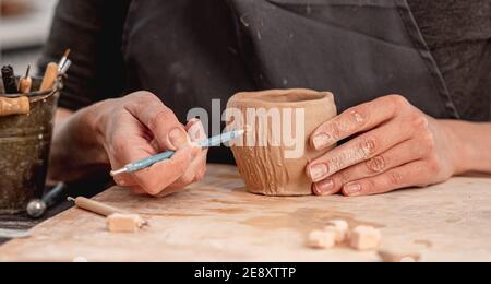 Potter mit Schnitzwerkzeug auf Becher Stockfoto