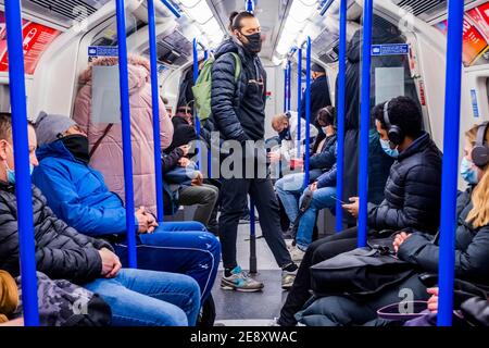 London, Großbritannien. Februar 2021. Die U-Bahn ist immer noch ziemlich voll trotz der neuen nationalen Lockdown, Stay at Home, Anweisungen. Die meisten Reisenden tragen Masken, da sie bereits obligatorisch sind. Kredit: Guy Bell/Alamy Live Nachrichten Stockfoto