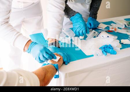 Krankenschwestern, die sich um einen älteren Patienten kümmern, indem sie einen intravenösen Patienten verabreichen Medikation Stockfoto