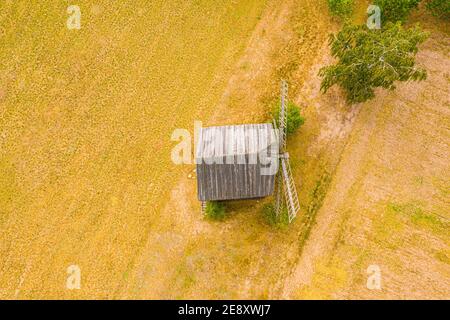 Alte Holzmühlenblätter aus der Nähe. Heller Himmel der untergehenden Sonne. Kleine Kreuzung im Hintergrund. Antenne Stockfoto