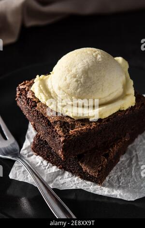 Brownie mit Vanilleeis Schaufel auf schwarzem Hintergrund Stockfoto