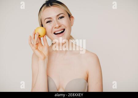 Junge schöne Frau mit Apfel in der Nähe Gesicht, Haut natürliche Pflege Kosmetik-Konzept Stockfoto