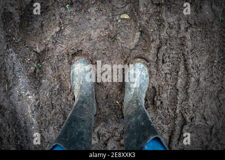 Paar schlammige gummistiefel im Schlamm. Stockfoto