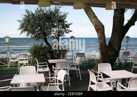Tische und Stühle in einem offenen Restaurant in der Nähe des Meeres. Stockfoto