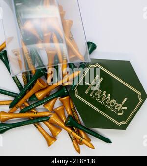 Foto einer Geschenkbox aus naturlackiertem Holz und grün lackierten Golf-T-Stücken, bedruckt mit Harrods Knightsbridge offen und verstreut London England UK Stockfoto