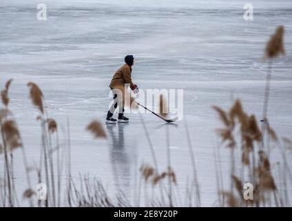 Eishockeyspieler auf einem gefrorenen See Stockfoto