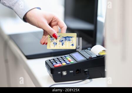 Weibliche Hand mit Kreditkarte in der Nähe des POS-Terminals Stockfoto