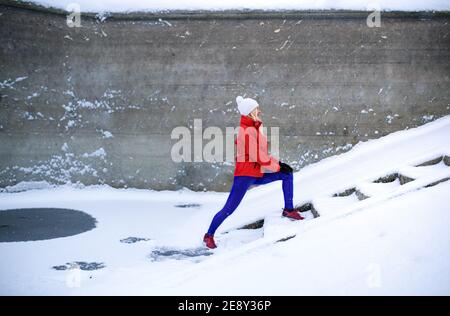Aktive ältere Frau im Freien im verschneiten Winter, Sport treiben. Stockfoto