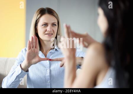 Zwei taube und stumme Frauen sprechen Gesten zu Hause Stockfoto