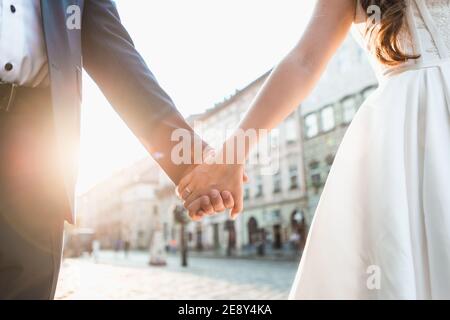 Paar hält Hände in Hochzeit im Freien Thema. Straßen der Stadt Stockfoto