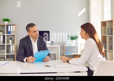 Seriöse HR-Führungskraft hört der Kandidatin zu, die über ihre Arbeit erzählt Erfahrung während des Vorstellungsgesprächs Stockfoto