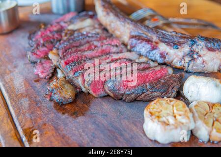 Abgehangenes Rindersteak Marmor Tomahawk auf Holzbrett mit Gewürzen. Close-up, Abendessen Konzept. Stockfoto