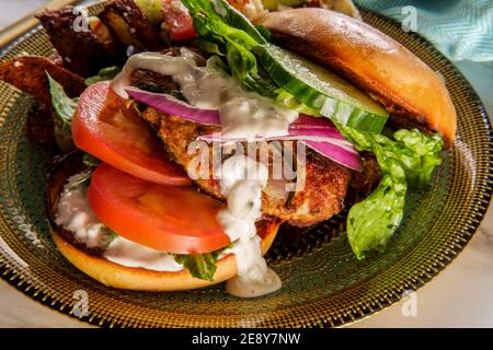 Griechischer gefüllter truthahn-Burger mit Gurkenscheiben und Tsatziki gekrönt Joghurtsauce serviert mit mediterranen Street Cart frittierten Kartoffeln mit Feta-Chees Stockfoto