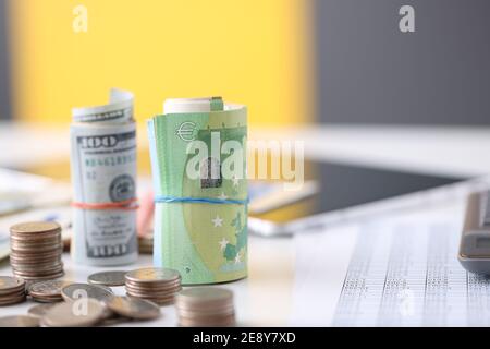 Papierrollen Dollar und Euro und Münzen liegen auf dem Tisch Nahaufnahme Stockfoto