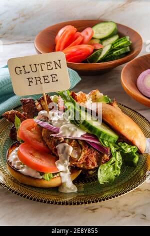 Griechischer gefüllter truthahn-Burger mit Gurkenscheiben und Tsatziki gekrönt Joghurtsauce serviert mit mediterranen Street Cart frittierten Kartoffeln mit Feta-Chees Stockfoto