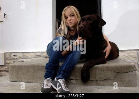 Clara Bellocq, 12 ans, pose avec Yago son labrador, sur le perron de sa maison le 5 octobre 2007, a Biarritz, Frankreich. Son autre chien Pirate, un caniche Bichon, fait Partie des huit chiens morts empoisonnes entre le 22 et le 30 septembre 2007 dans le quartier du Golf de Biarritz. Yago le labrador a du subir un lavage d'estomac apres avoir ingurgite une tacisse suspecte. Eine Frage an eine äte ouverte. Jules Motte/ABACAPRESS.COM Stockfoto