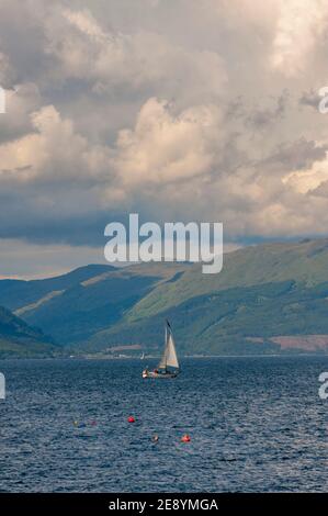 Segelyacht im Firth of Clyde vor der Südküste bei greenock Argyle Hills dahinter. Stockfoto