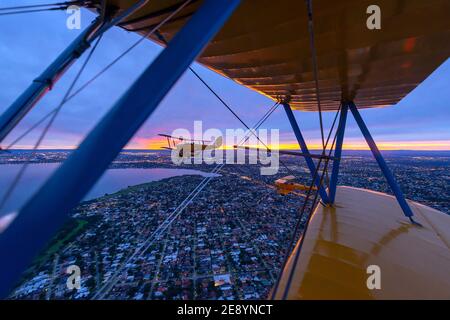 Eine Formation von neun De Havilland DH.82 Tiger Moth Doppelflugzeugen der 30er Jahre, die über Perth in Western Australia fliegen, während eines Morgendämmerung-Patrouillenfluges zum Anzac Day. Stockfoto