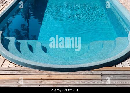 Neue moderne Fiberglas Kunststoff Schwimmbad Eingang Schritt mit sauber Frisches, erfrischendes blaues Wasser an einem heißen Sommertag Hof oder Resort Hotel Spa Stockfoto