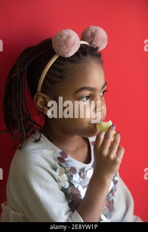 Kleines afro Mädchen essen einen Apfel Stockfoto