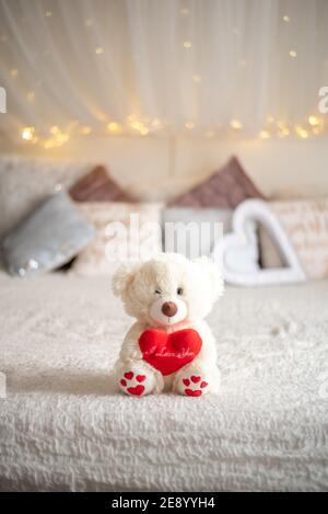 Teddybär Umarmung Herz Kissen auf dem Bett, Valentine's Konzept Stockfoto
