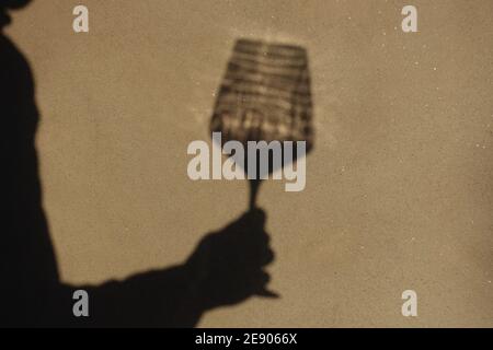 Schatten an der Wand einer Sommelierin allein mit einem Glas Wein. Mit einem gass of Wine Konzept Stockfoto