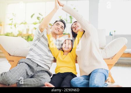 Glückliche Familie bilden Hausdach mit ihren Händen zu Hause Stockfoto