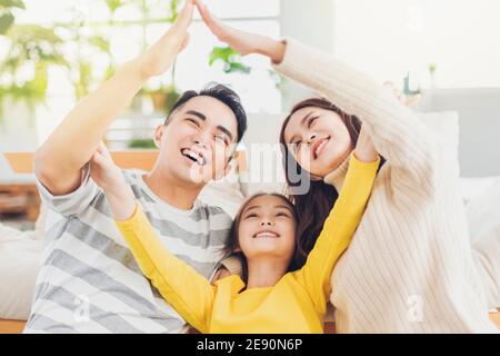 Glücklich asiatische Familie bilden Hausdach mit ihren Händen an Zu Hause Stockfoto