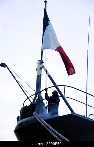 Ein Mitglied des französischen Militärs hält die Flagge an Bord des französischen Hubschrauberträgers Jeanne d'Arc, nachdem er am 28. Dezember 2007 am Pier 92 in New York City, USA, im Hafen von New York angedockt ist. Das französische Kriegsschiff, das als Ausbildungsschiff für Midshipmänner der französischen Marine dient, trug über 10,000 französische Bücher, die Kindern angeboten werden, die an New Yorks neu gestarteten Französisch-Englisch-Doppelsprachenprogrammen teilnehmen, sowie an Schulen in New Orleans, die von Hurrikanin Katrina verwüstet wurden. Foto von Gregorio Binuya/ABACAPRESS.COM Stockfoto