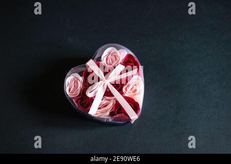 Herzförmige Geschenkbox auf schwarzem Hintergrund Stockfoto