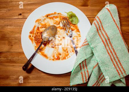 Teller mit Pasta mit Sauce fertig und schmutzig auf einem Holztisch. Draufsicht Stockfoto