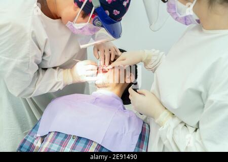 Team von Zahnärzten, die an einem Patienten Stockfoto