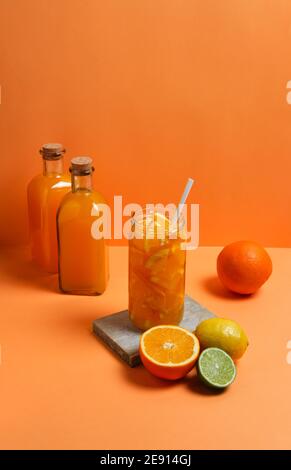 Orangensaft in Gläsern mit seinen Früchten auf einer Orange Hintergrund Stockfoto