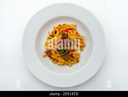 Frische italienische Tagliatelle mit Schinken und Erbsen Sauce. Traditionelle italienische Pasta. Stockfoto