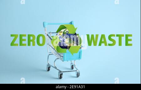 Kleiner Planet Erde im Warenkorb auf farbigem Hintergrund. Zero Waste Konzept Stockfoto