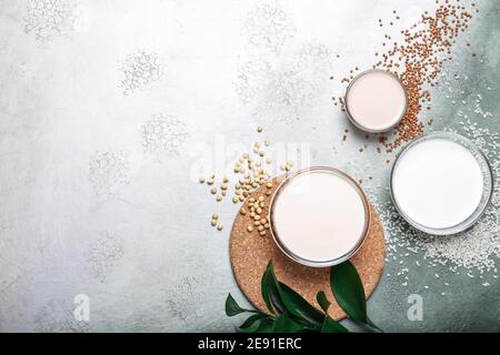 Gläser aus verschiedenen veganen Milch auf farbigem Hintergrund Stockfoto