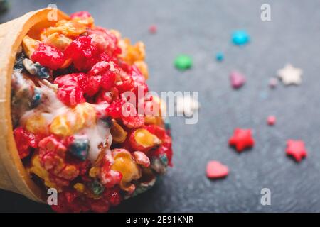 Waffelkegel mit Popcornkugel auf dunklem Hintergrund, Nahaufnahme Stockfoto