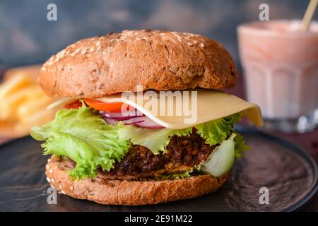 Tablett mit leckeren Burger auf dem Tisch Stockfoto